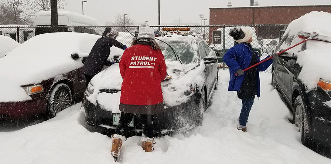 Student Patrol Members cleaning snow off cars
